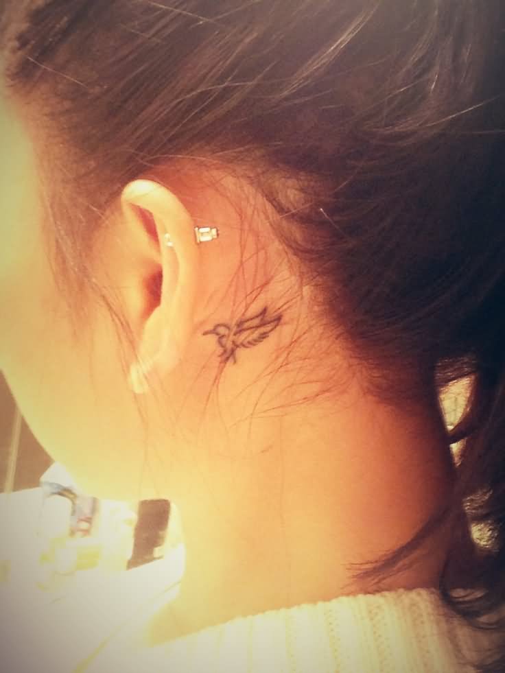 Cute Black Outline Bird Tattoo On Girl Left Behind The Ear