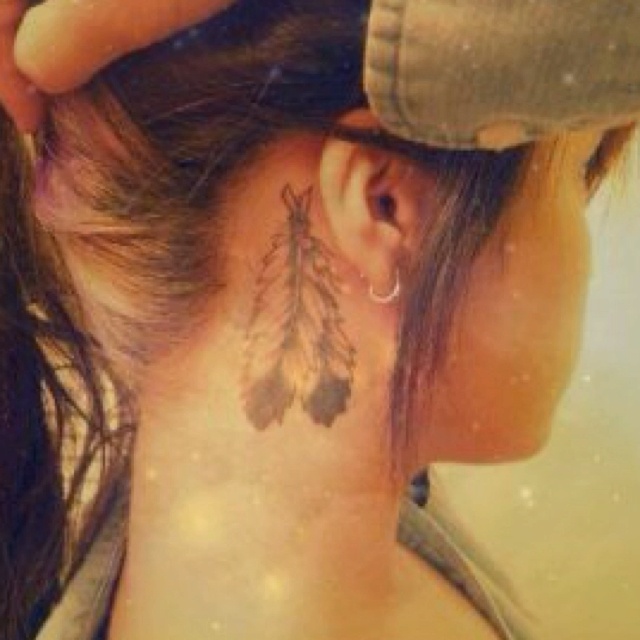 Grey Ink Feathers Tattoo On Girl Right Behind The Ear