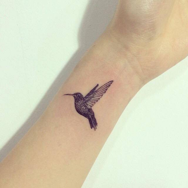 Grey Ink Flying Colibri Tattoo On Left Wrist