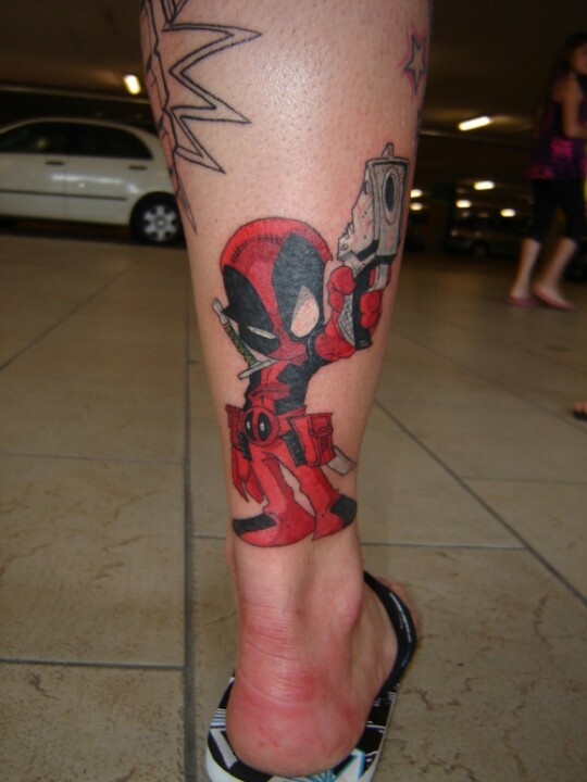 Gun In Deadpool Hand Tattoo On Leg