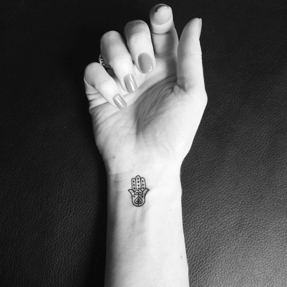 Little Black Outline Hamsa Tattoo On Girl Right Wrist