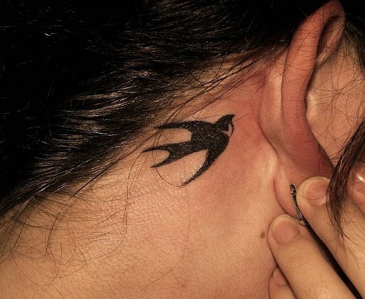 Nice Black Bird Tattoo On Right Behind The Ear