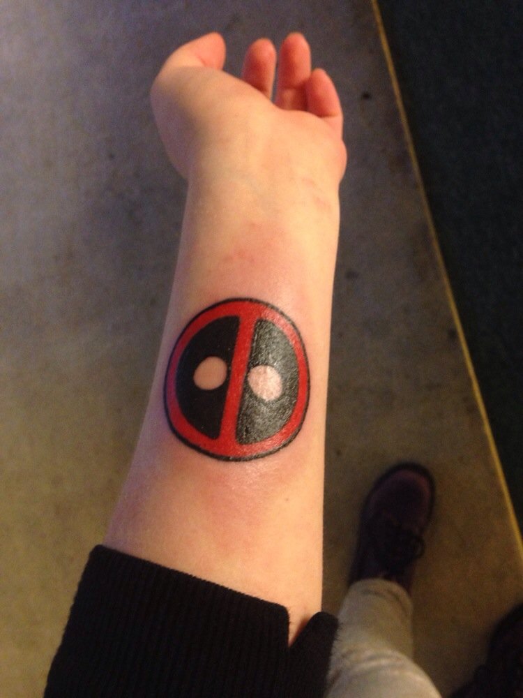 Red And Black Deadpool Logo Tattoo On Left Forearm