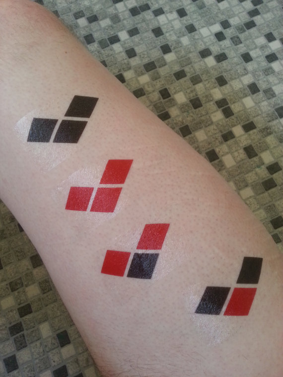 Red And Black Harley Quinn Symbol Tattoos On Arm
