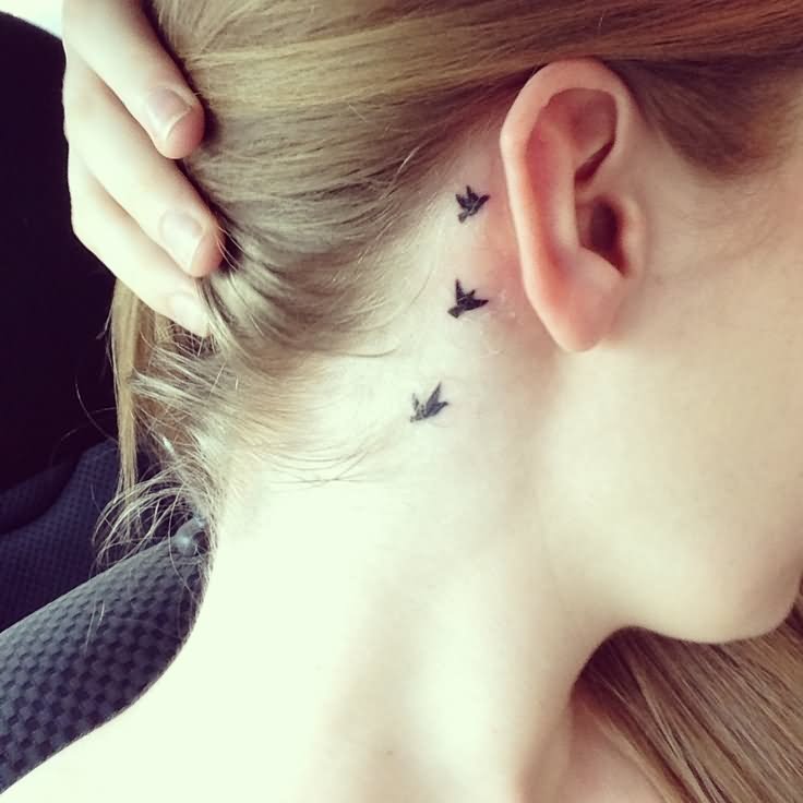 Silhouette Flying Birds Tattoo On Girl Right Behind The Ear