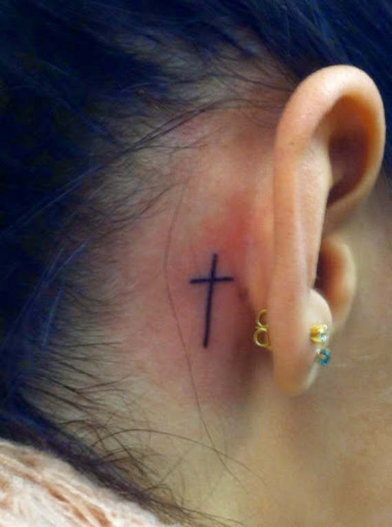 Simple Black Line Cross Tattoo On Right Behind The Ear