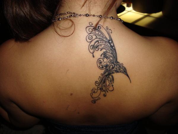 Tribal Colibri Tattoo On Girl Upper Back