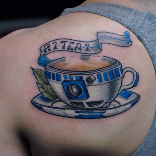 Amazing Blue Ink Teacup Tattoo On Left Back Shoulder