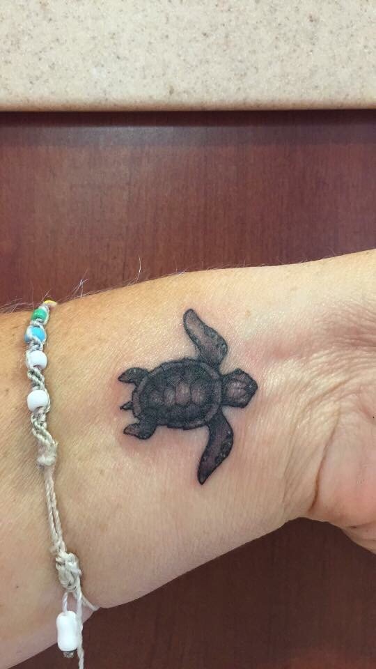 Black And Grey Baby Turtle Tattoo On Left Wrist