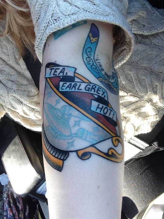 Colored Banner And Teacup Tattoo On Left Arm