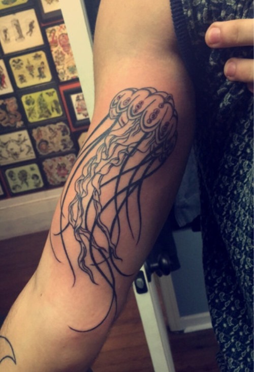 Girl showing Her Jellyfish Tattoo On Bicep