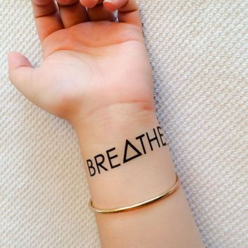 Attractive Breathe Lettering Tattoo On Wrist