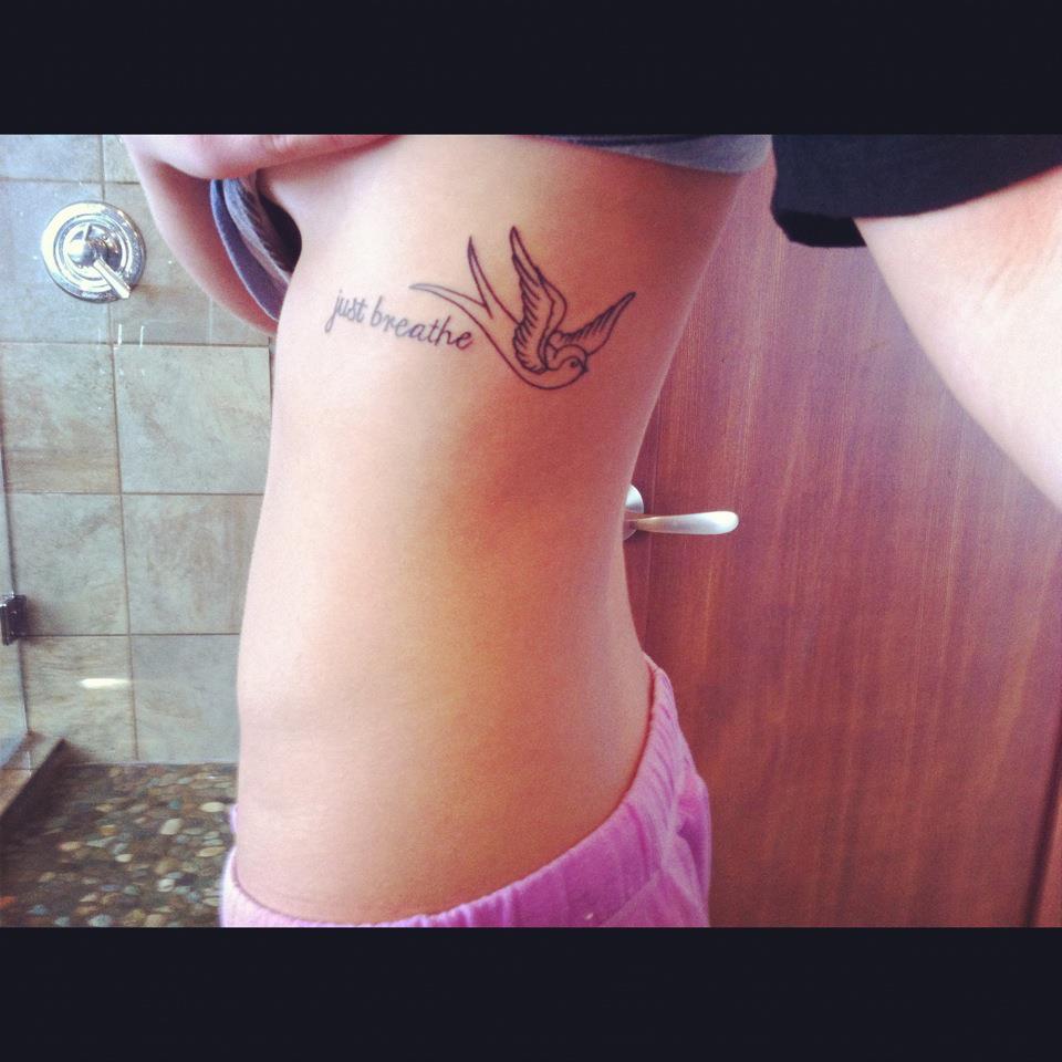Black Outline Bird With Just Breathe Lettering Tattoo On Girl Side Rib