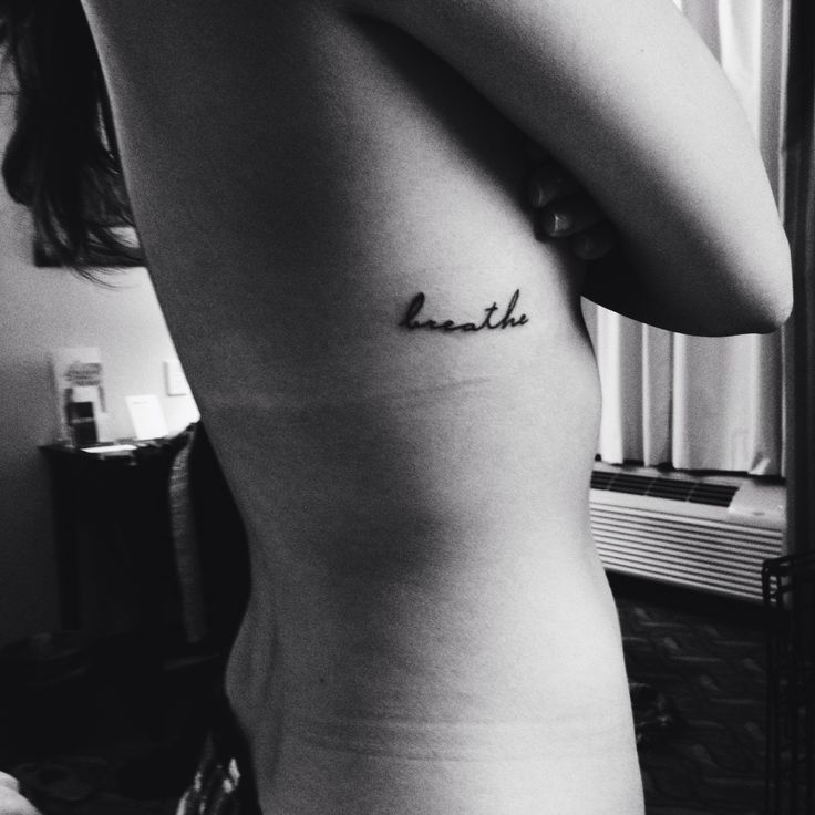 Breathe Lettering Tattoo On Girl Right Side Rib