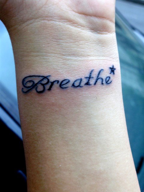 Breathe Lettering With Star Tattoo On Wrist