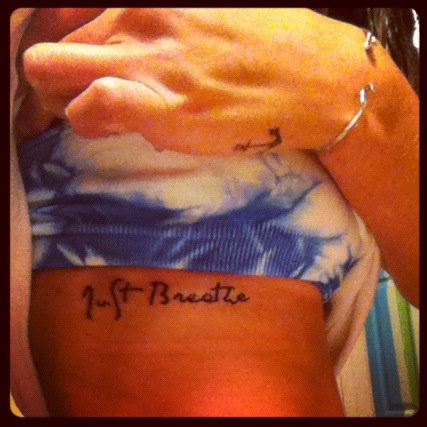 Just Breathe Lettering Tattoo On Girl Right Side Rib