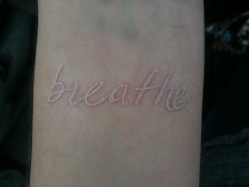 Simple White Ink Breathe Lettering Tattoo Design For Wrist