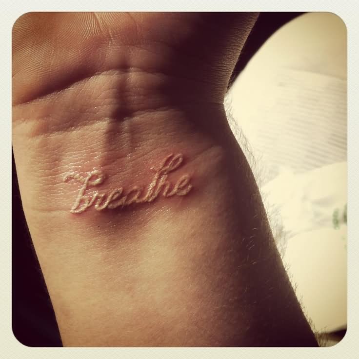 White Ink Breathe Lettering Tattoo On Wrist