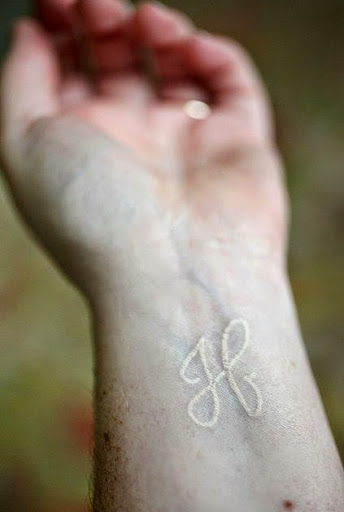 White Ink Breathe Symbol Tattoo On Left Wrist