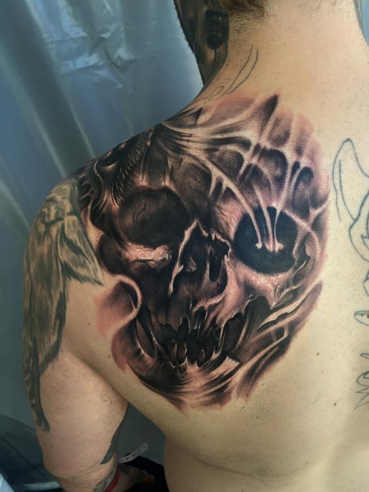 Black And Grey Skull Tattoo On Left Back Shoulder by Carl Grace