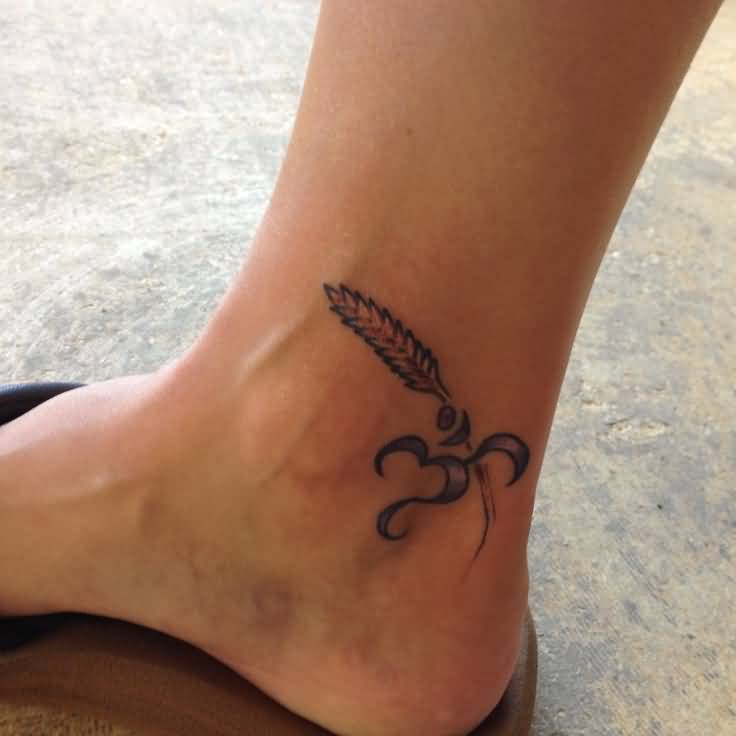 Black Ink Om With Wheat Tattoo On Ankle