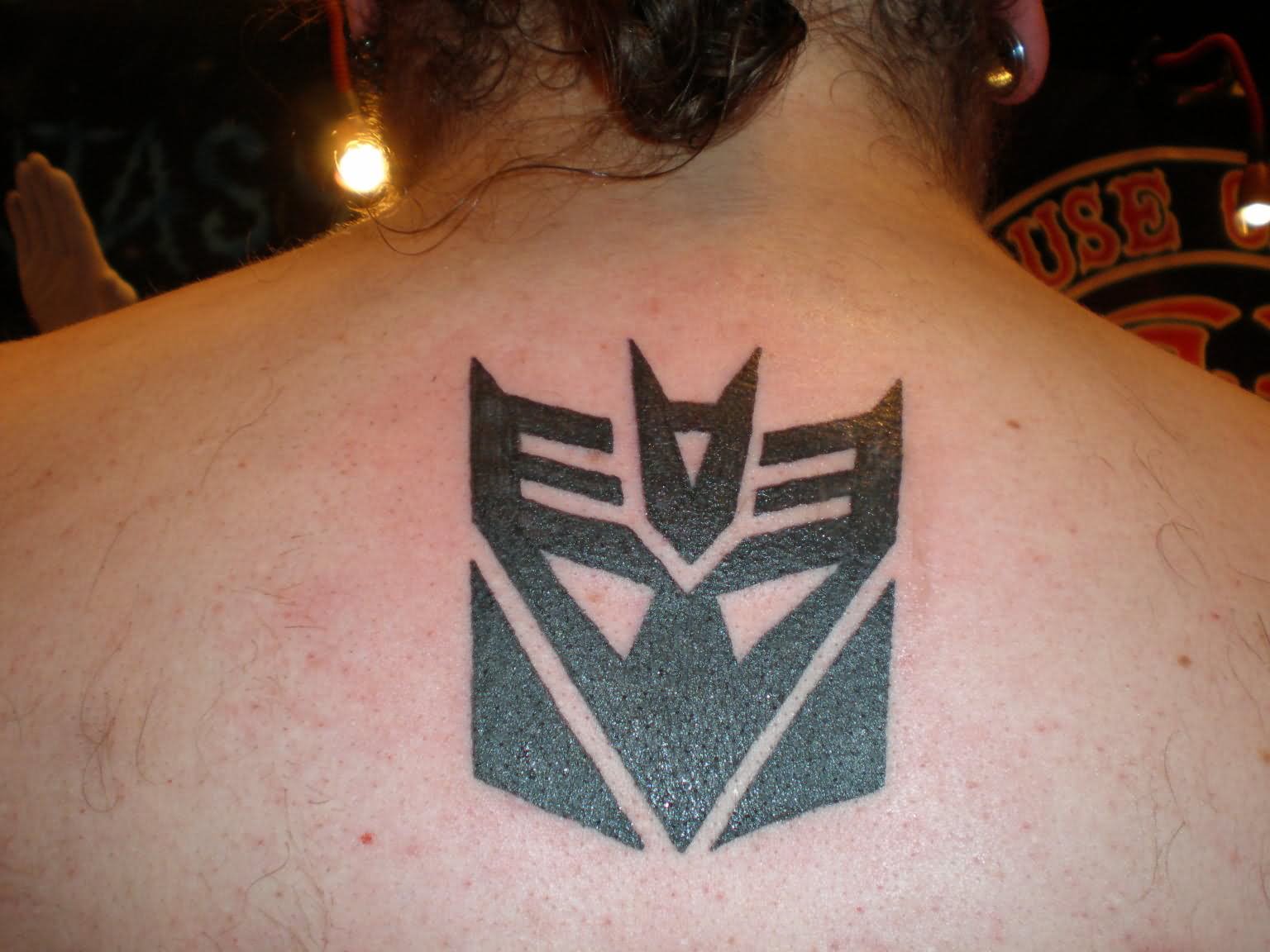 Black Transformer Logo Tattoo On Upper Back