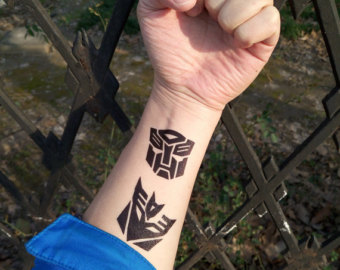 Black Two Transformer Symbols Tattoo On Left Wrist