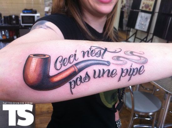 Ceci N’est Pas Une Pipe – Pipe Tattoo On Girl Right Arm By Jon Mesa