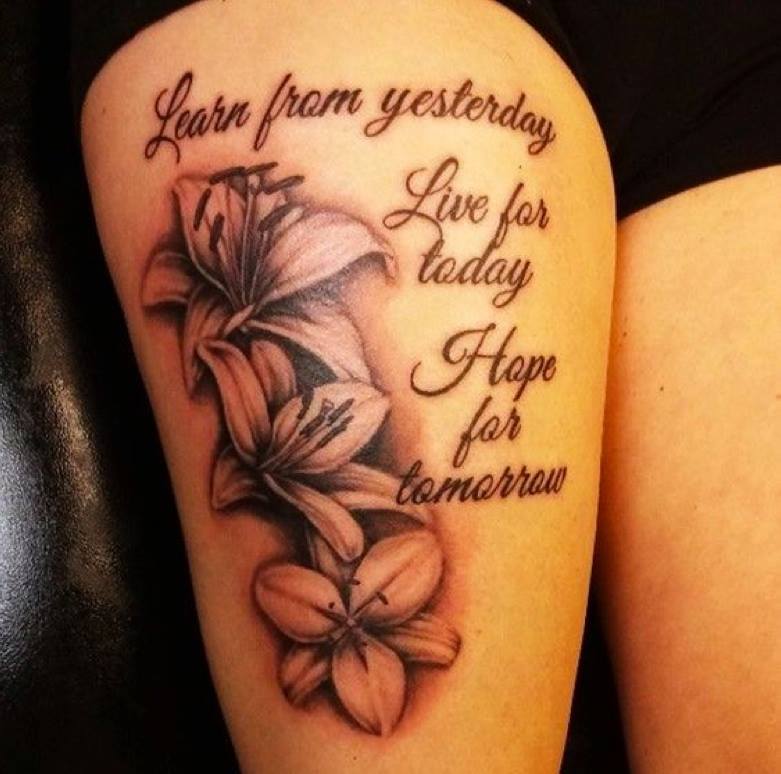 Grey Ink Quote And Lily Flowers Tattoo On Thigh