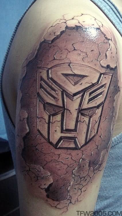 Grey Ink Ripped Skin Transformer Logo Tattoo On Right Shoulder