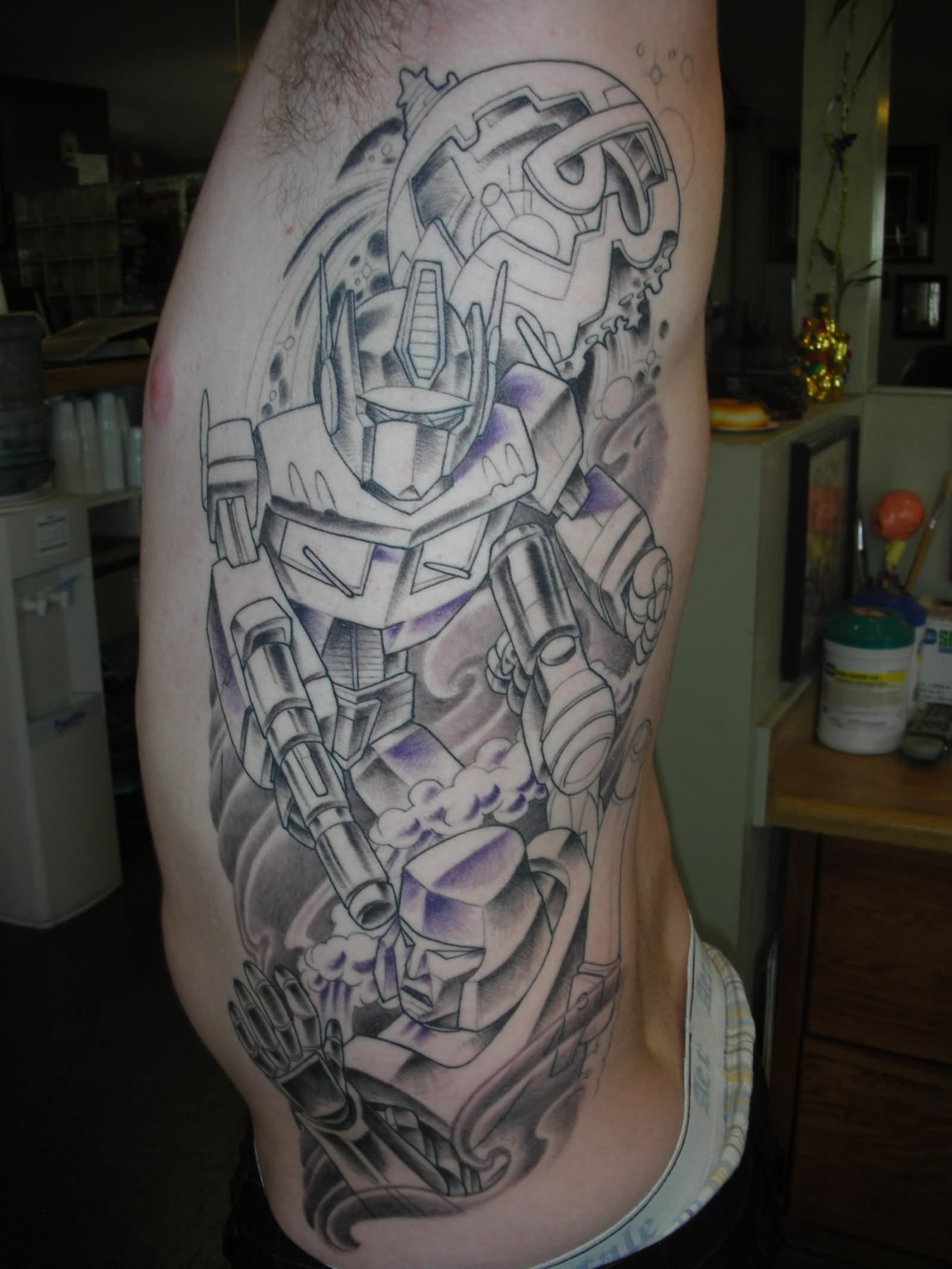 Grey Ink Transformer Logo Tattoo On Man Side Rib