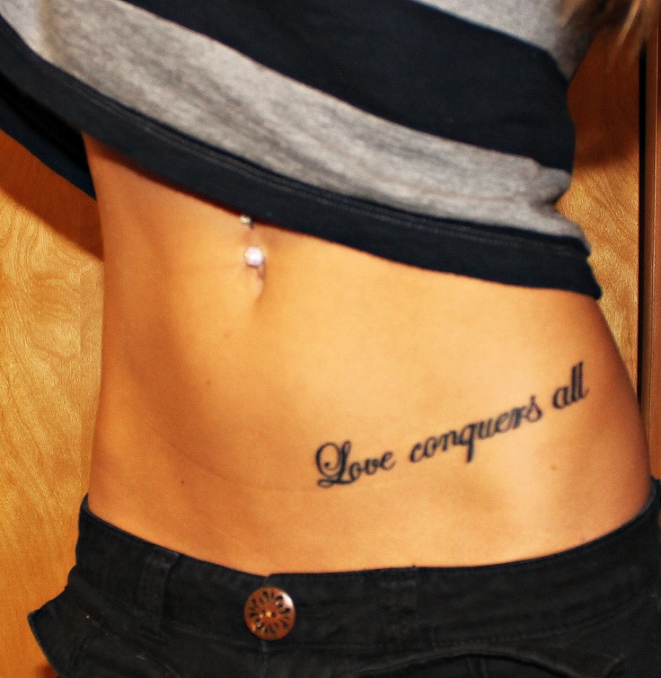Love Conquers All Words Tattoo On Girl Left Hip