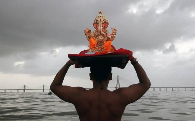 Man With Lord Ganesha Idol For Immersion During Ganesh Chaturthi Celebration