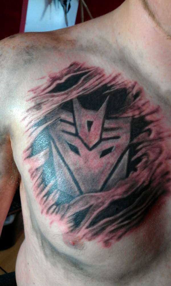 Ripped Skin Transformer Logo Tattoo On Man Right Chest