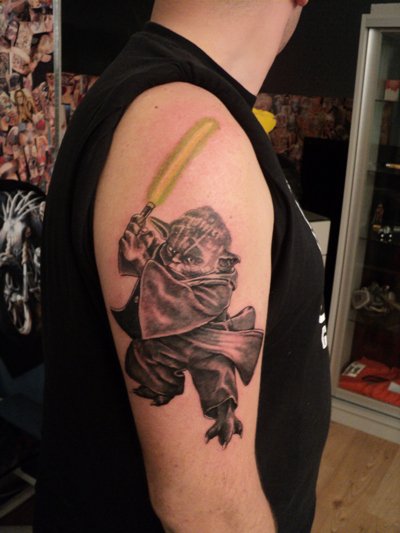 Black Ink Yoda With Lightsaber Tattoo On Right Half Sleeve
