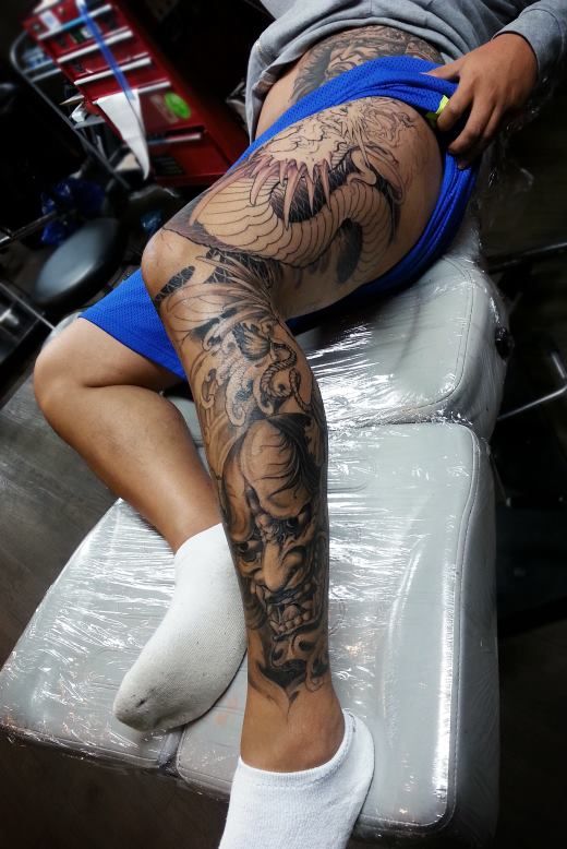 Guy Showing His Hannya Tattoo On Left Leg
