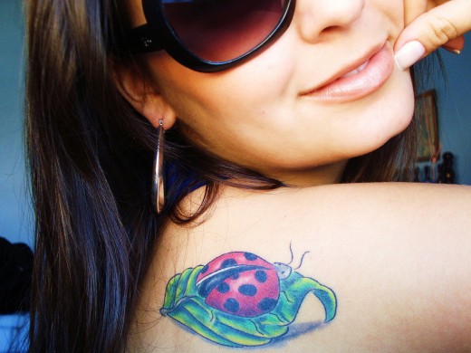 Beautiful Girl With Green Leaf And Ladybug Tattoo