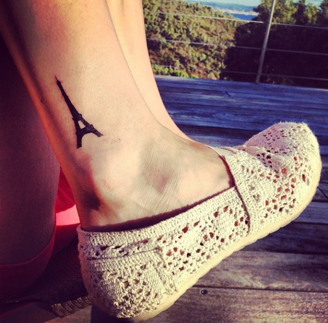 Black Ink Eiffel Tower Tattoo On Girl Leg