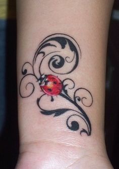 Black Tribal Design And Ladybug Tattoo On Wrist