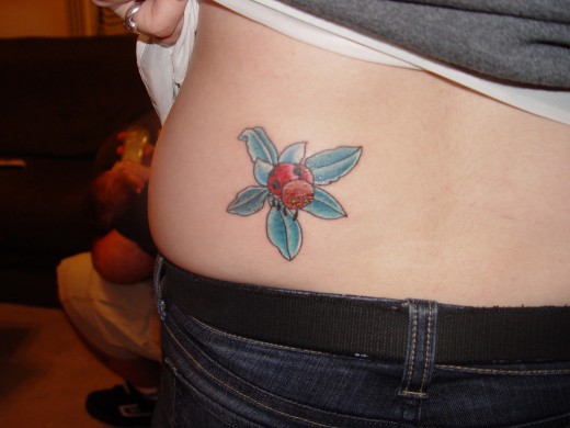 Blue Flower And Ladybug Tattoo On Lower Back