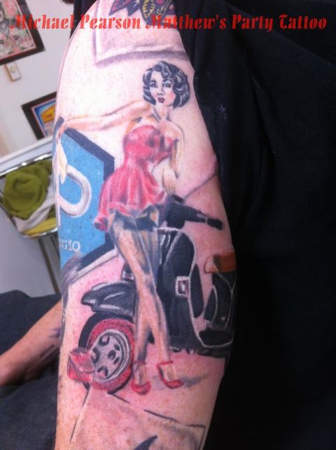 Girl With Black Scooter Tattoo On Bicep