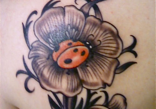Grey Ink Flower And Ladybug Tattoo