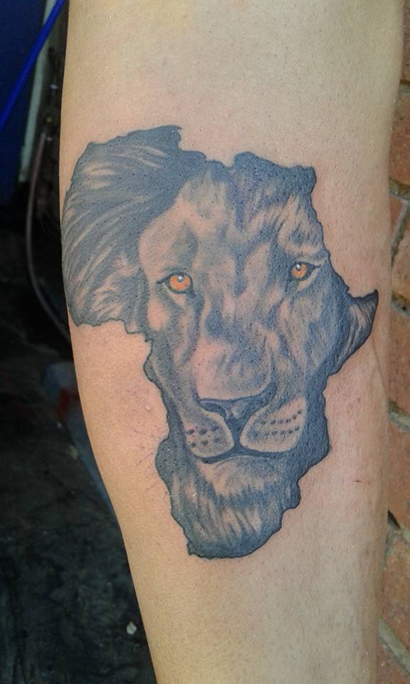 Grey Ink Lion Face in African Map Tattoo On Arm by Kyle Kemp
