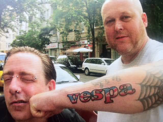 Man Showing His Colorful Vespa Word Tattoo