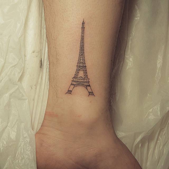Nice Grey Eiffel Tower Tattoo On Leg