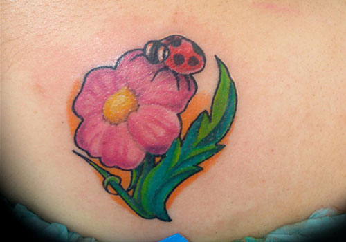 Pink Flower And Ladybug Tattoo On Lower Back