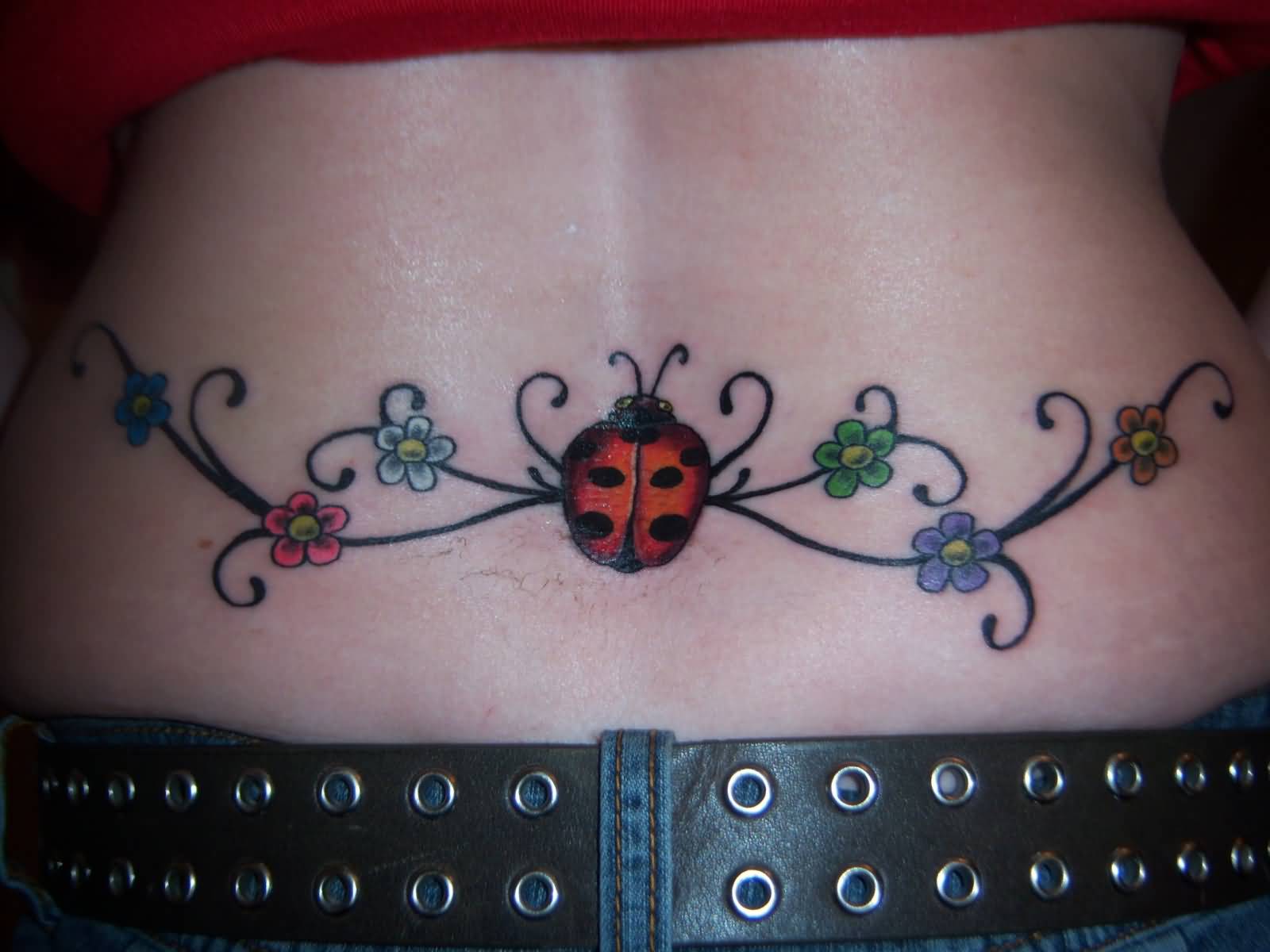 Small Colored Flowers And Ladybug Tattoo On Lower Back