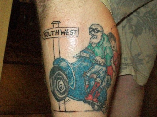 South West Sighn Board And Couple Riding Scooter Tattoo On Leg