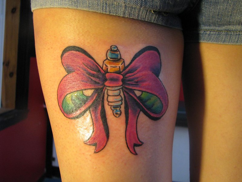 Bow And Spark Plug Tattoo On Thigh