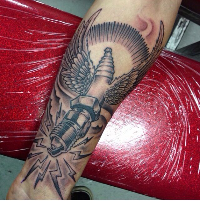 Grey Ink Angel Winged Spark Plug Tattoo On Forearm